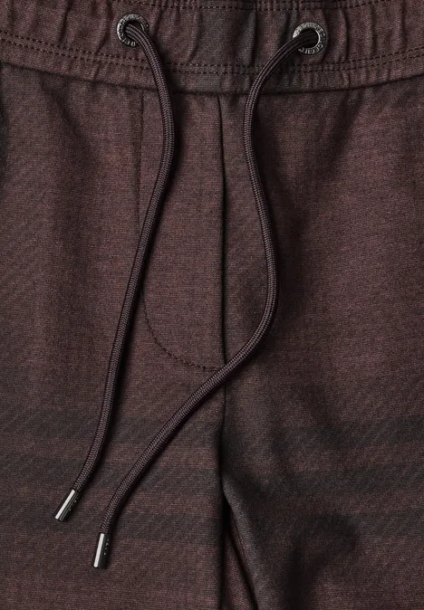Nahaufnahme einer braunen Hose mit Kordelzug und Metallenden.