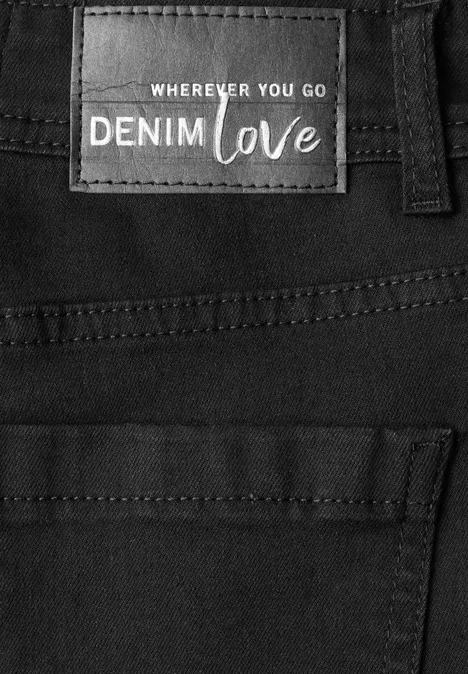 Czarne dżinsy z naszywką 'Wherever you go Denim Love' przy pasie.