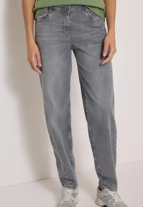 High Waist Barrel Leg Jeans w stylu Loose Fit light grey wash Osoba ma na sobie proste szare dżinsy i sneakersy, stojąc na jasnym tle.