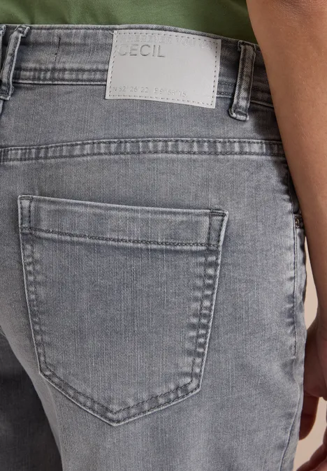 High Waist Barrel Leg Jeans w stylu Loose Fit light grey wash Tył osoby w szarych dżinsach z metką marki nad tylną kieszenią.