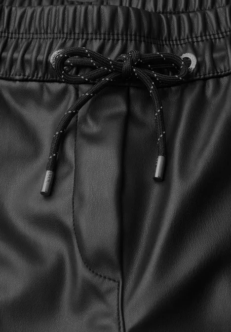Schwarze Kunstlederhose mit elastischem Bund und schwarzen Kordeln mit Reflektorpunkten.