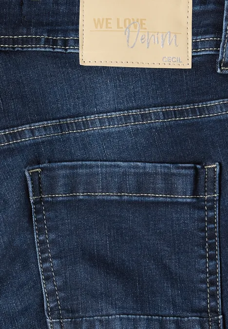 Nahaufnahme einer dunkelblauen Jeans mit Seitentasche und Lederetikett 'WE LOVE Denim'.