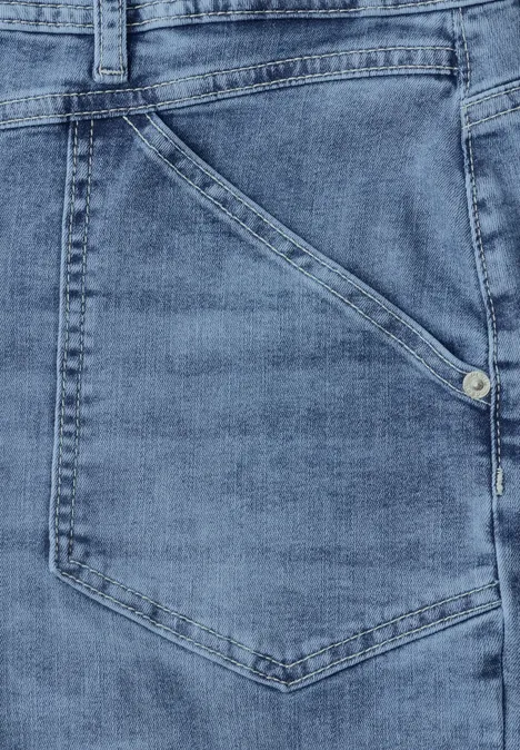 Nahaufnahme einer blauen Jeanstasche mit seitlicher Naht und Metallniete.