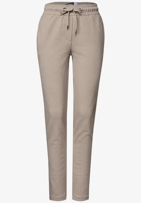 Enganliegende, bequeme Sweatpants in Beige mit Tunnelzug an der Taille und schmal zulaufenden Beinen.