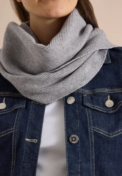 Gros plan sur un snood gris et une veste en jean, centré sur le cou et le torse.