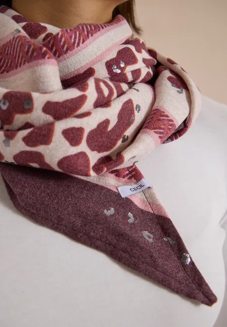 Foulard triangulaire à motif léopard berry red Gemustertes Halstuch in Creme- und Burgundertönen um den Hals gelegt.
