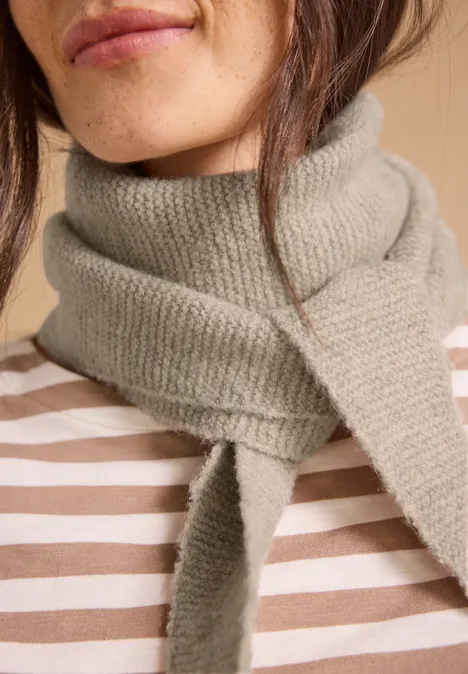 Écharpe à motif mélangé en forme de losange powder beige melange Nahaufnahme einer Person mit grauem Strickschal um den Hals und gestreiftem Oberteil.