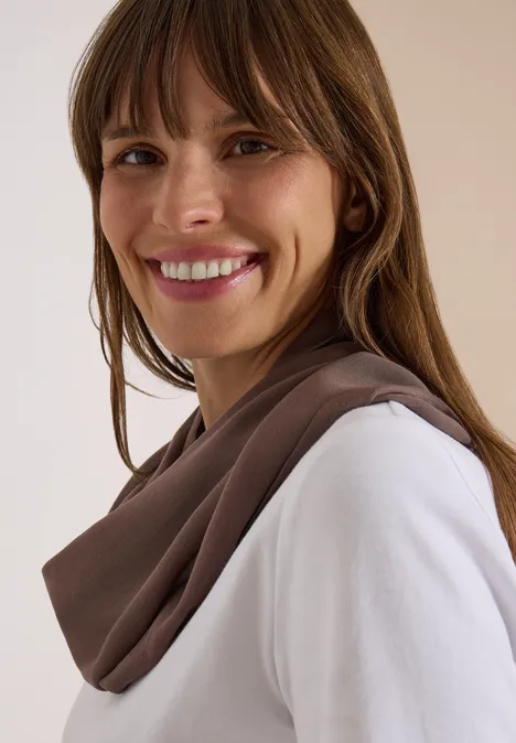 Écharpe Loop unie urban taupe Femme souriante aux cheveux bruns portant un pull blanc et une écharpe marron.