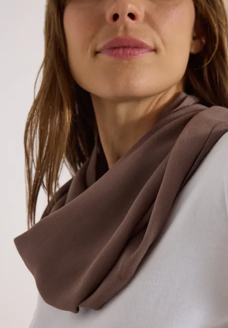 Écharpe Loop unie urban taupe Gros plan d'une femme portant un foulard marron doux autour du cou et un haut blanc.