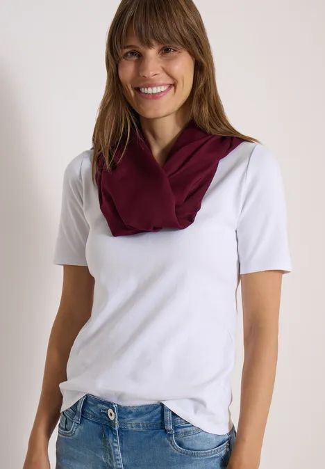 Écharpe Loop unie red wine Femme souriante en t-shirt blanc, jean bleu et foulard grenat.