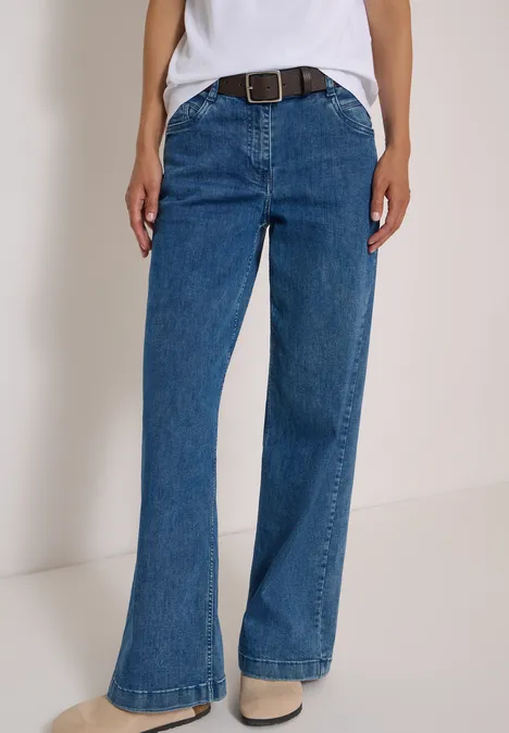 Basic Gürtel mit quadratischer Schnalle Dark Brown Eine Person trägt hoch sitzende, leicht ausgestellte blaue Jeans mit Gürtel.