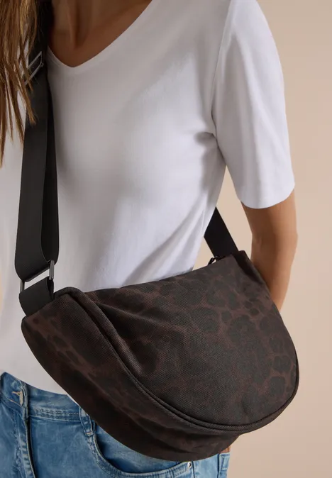 Braune Satteltasche mit dezentem Animalprint, kombiniert mit weißem T-Shirt und Jeans.