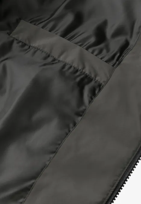 Nahaufnahme des schwarzen, seidigen Innenfutters einer Jacke mit sichtbarer Naht und Reißverschluss.