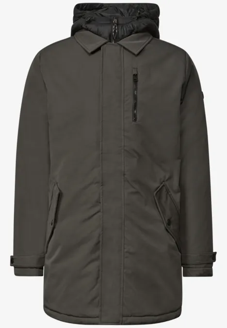 Ein dunkelgrüner, mittellanger Parka mit Steppfutter, Kapuze, verdecktem Frontreißverschluss und Taschen.
