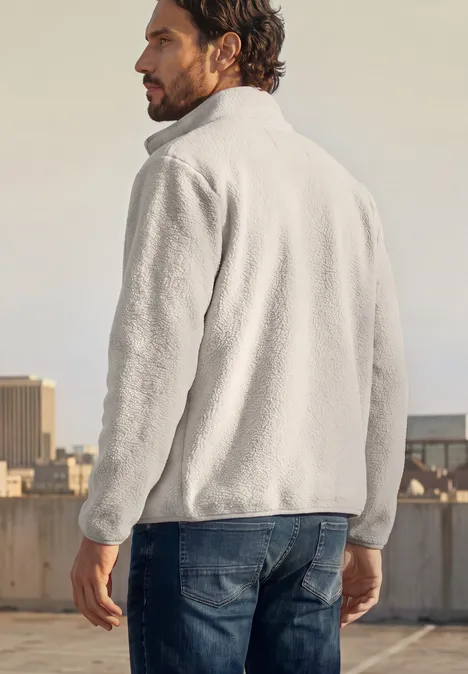 Veste en peluche avec col montant et fermeture à zip classic beige Homme vu de dos en veste polaire grise sur un toit avec la ville à l’arrière-plan.