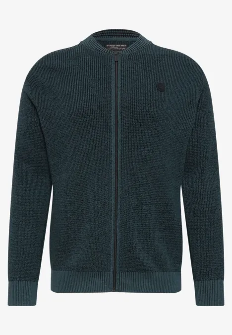 Gilet zippé vert foncé en maille, douillet en polaire, avec discret logo sur la poitrine.