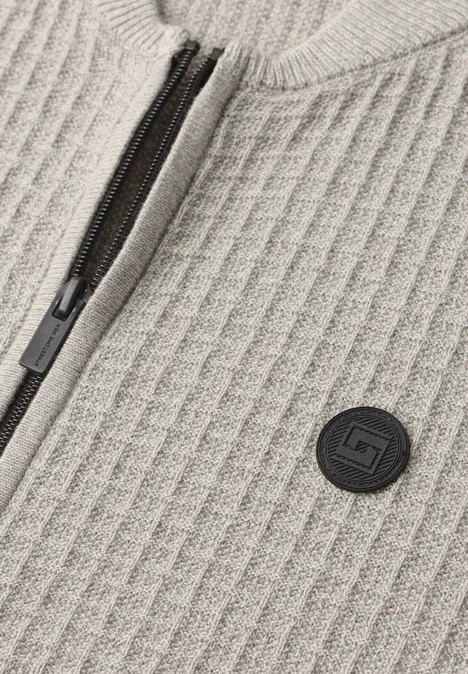 Tissu tricoté côtelé beige, fermeture éclair noire et patch logo rond