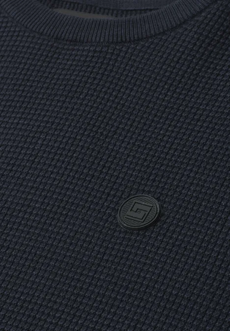 Trui met ronde hals en schouderdetail dark basic blue Close-up van een donkerblauwe, wafelgebreide trui met een klein rond merkembleem.