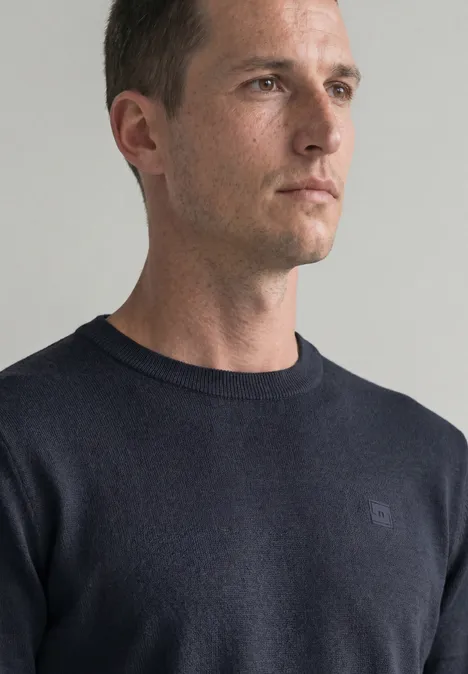 Eenvoudige trui met ronde hals in effen kleur dark basic blue Portret van een man in een donkerblauwe trui, in profiel tegen een neutrale achtergrond.