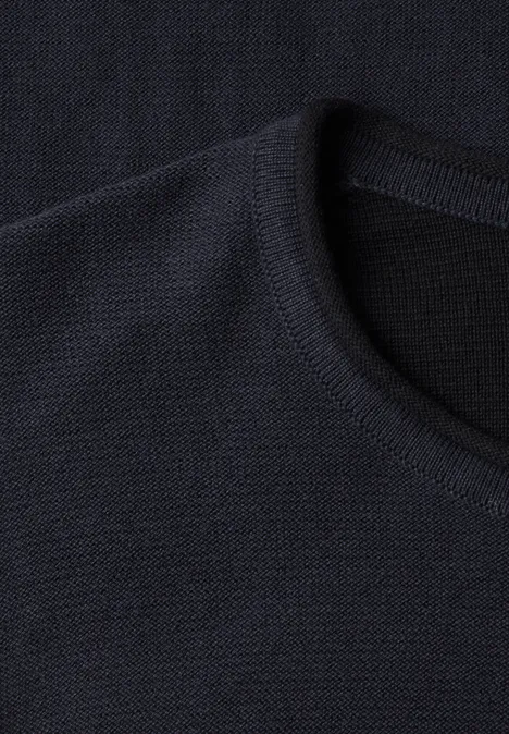 Dunkler, gerippter Rundhalsausschnitt eines Strickpullovers.