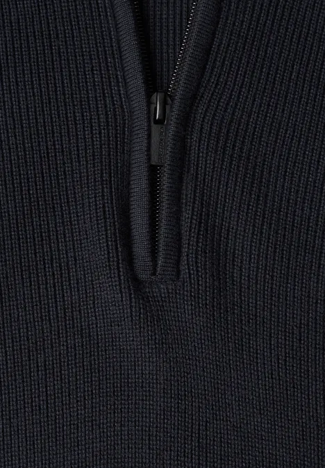 Schwarzer, grobgestrickter Pullover mit kurzem Reißverschluss vorne.