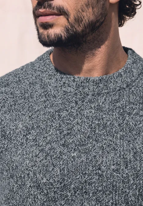 Pullover mit Rundhals und Wollanteil vintage blue Close-up eines bärtigen Mannes im grauen Strickpullover, Unterkiefer und Oberkörper sichtbar.