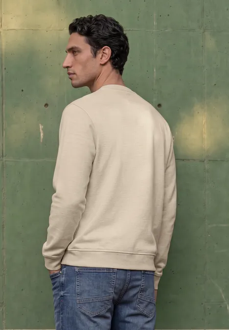 Sweat-shirt en tissu éponge avec détails en tricot côtelé canvas beige Un homme de profil devant un mur vert, portant un sweat beige et un jean bleu.