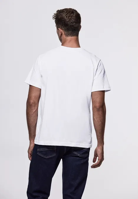 Homme de dos en t-shirt blanc et jean sur fond clair.