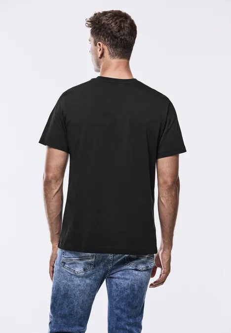 Homme de dos en t-shirt noir et jean.