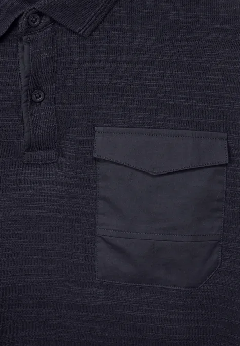 Polo sombre avec poche poitrine et patte à boutons.