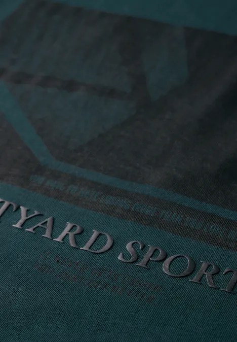 Nahaufnahme eines grünen Stoffes mit dem Text 'YARD SPORT'.