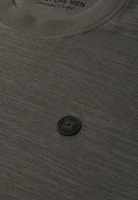 Nahaufnahme eines grauen T-Shirts mit kleinem, rundem Logo auf der Brust.