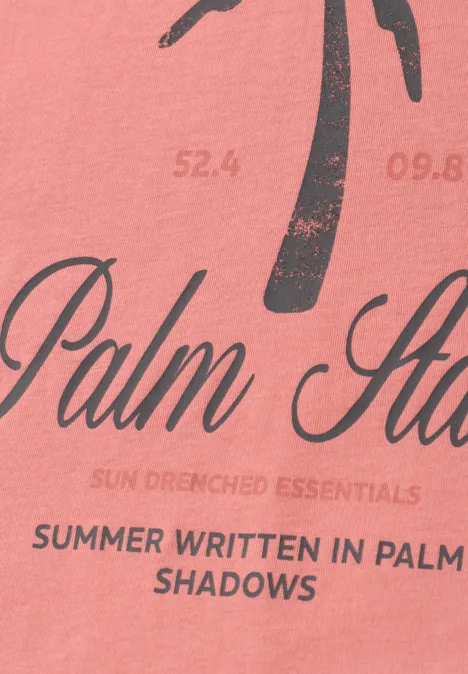 Roze T-shirt met gestileerde palmboom en tekst "Summer written in palm shadows".