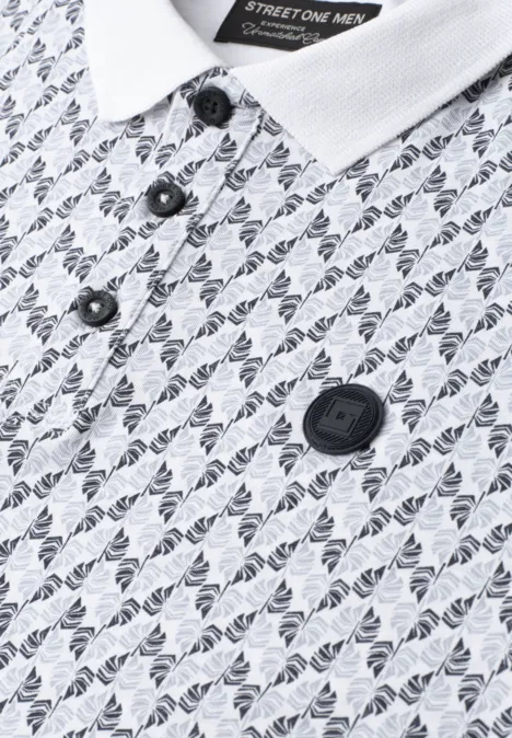 Nahaufnahme eines weißen Poloshirts mit feinem Monogramm-Muster, schwarzer Knopfleiste und Markenlogo-Badge.