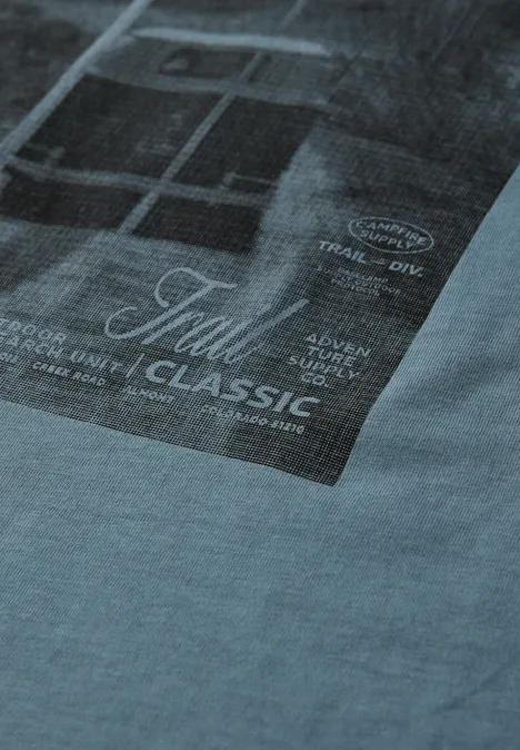 Lichtblauw T-shirt met een rechthoekige, donkere foto-print en de tekst 'Tull Classic' op de voorkant.