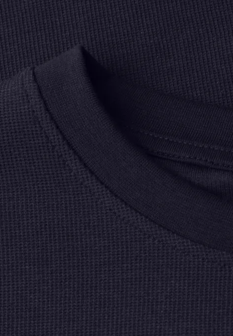 Nahaufnahme eines schwarzen, feinmaschigen Rundhals-Shirt-Kragens