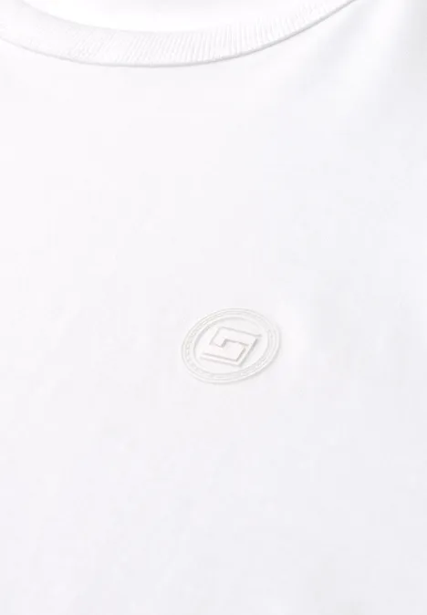 Effen shirt met lange mouwen en ronde hals bright white Close-up van een wit T-shirt met subtiel rond geborduurd logo op de borst.