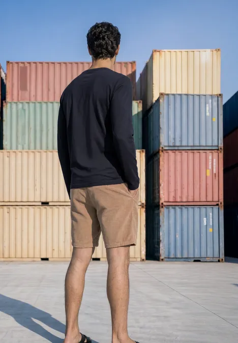 Langarm Shirt mit Rundhals in Unifarbe dark ink blue Ein Mann in Shorts und langärmeligem Shirt steht vor gestapelten Frachtcontainern.