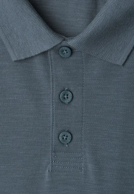 Poloshirt met lange mouwen en zakdetail vintage blue Close-up van een blauwgrijs poloshirt met kraag en drie knopen.