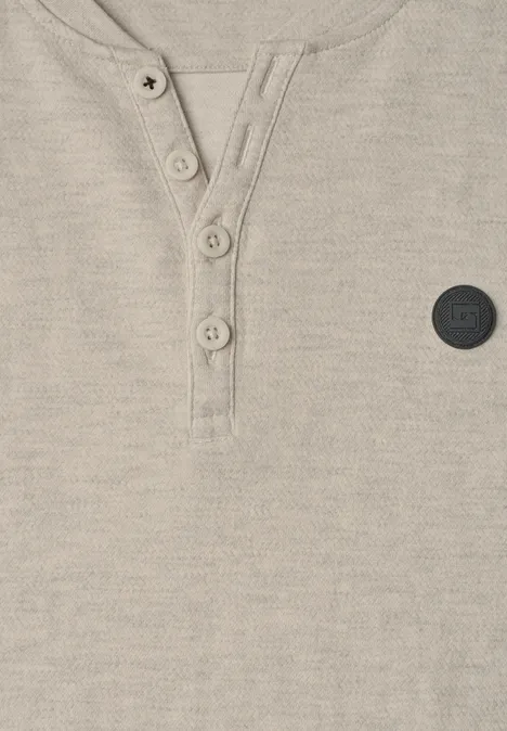 Beżowy, teksturowany shirt Henley z zapięciem na guziki i małą czarną naszywką.