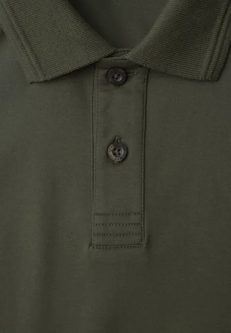 Gros plan d’un polo vert foncé avec col et patte de boutonnage