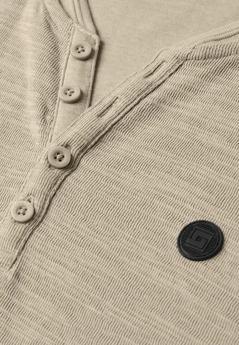 Beige Feinstrick-Henley mit Knopfleiste und rundem Logo-Patch auf der Brust.