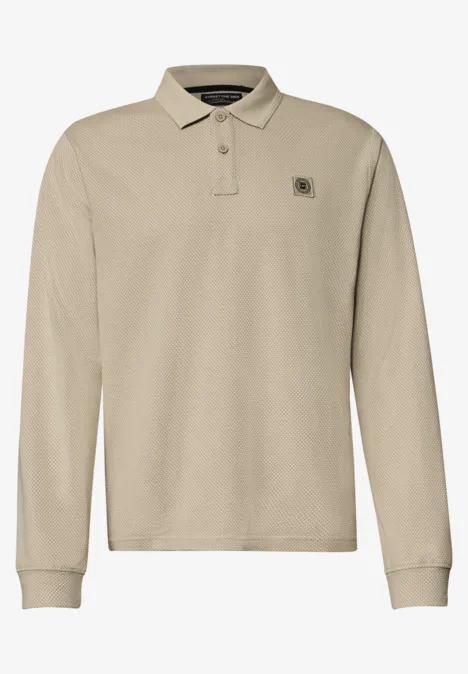 Beiges Langarm-Poloshirt mit Knopfleiste und dezentem Logo auf der Brust.