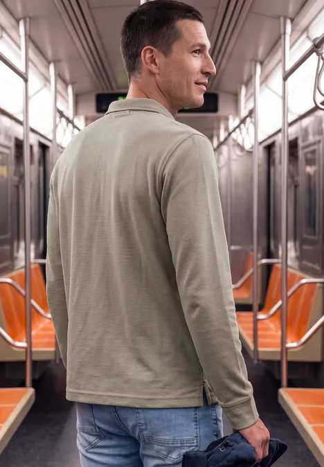 Ein Mann steht in der U-Bahn, schaut über die Schulter zur Kamera.