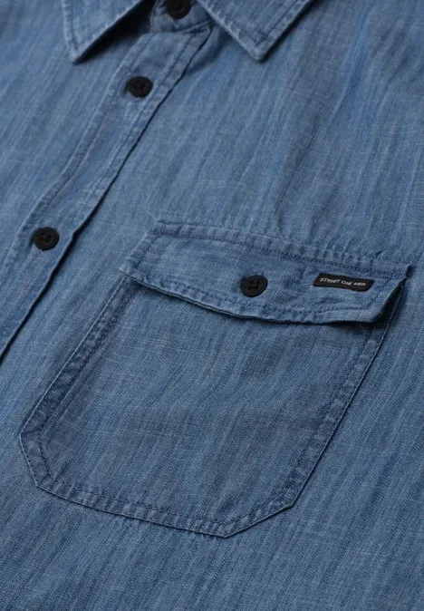 Niebieska koszula denim z kieszenią na piersi, czarnymi guzikami i delikatną fakturą