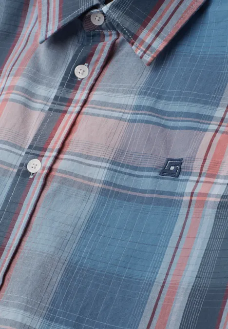 Close-up van een blauw-grijs geruit overhemd met rode strepen en witte knopen.