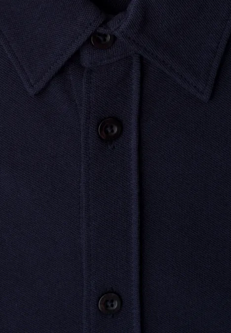 Zbliżenie na granatową koszulę z kołnierzykiem i czarnymi guzikami.