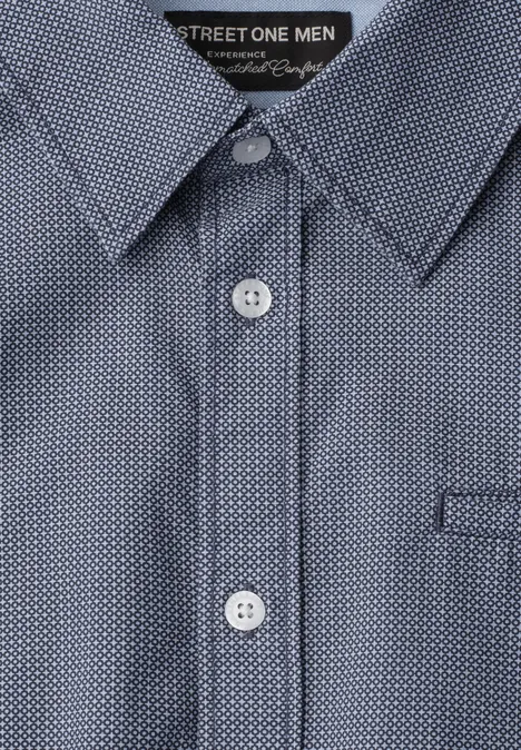 Blauw overhemd met wit stippenpatroon, puntsgewijze kraag en witte knopen.