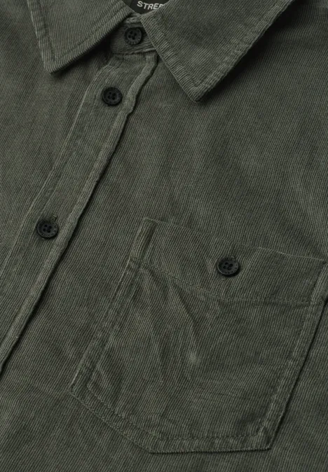 Effen corduroy overhemd met lange mouwen light moss green Close-up van een donkergroen corduroy overhemd met knoopsluiting en borstzak.