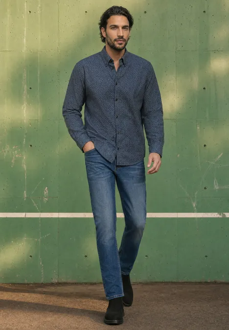 Langarm Popeline Hemd mit Print dark ink blue Ein Mann in dunkelblauem Hemd und Jeans steht lässig vor einer grünen Wand